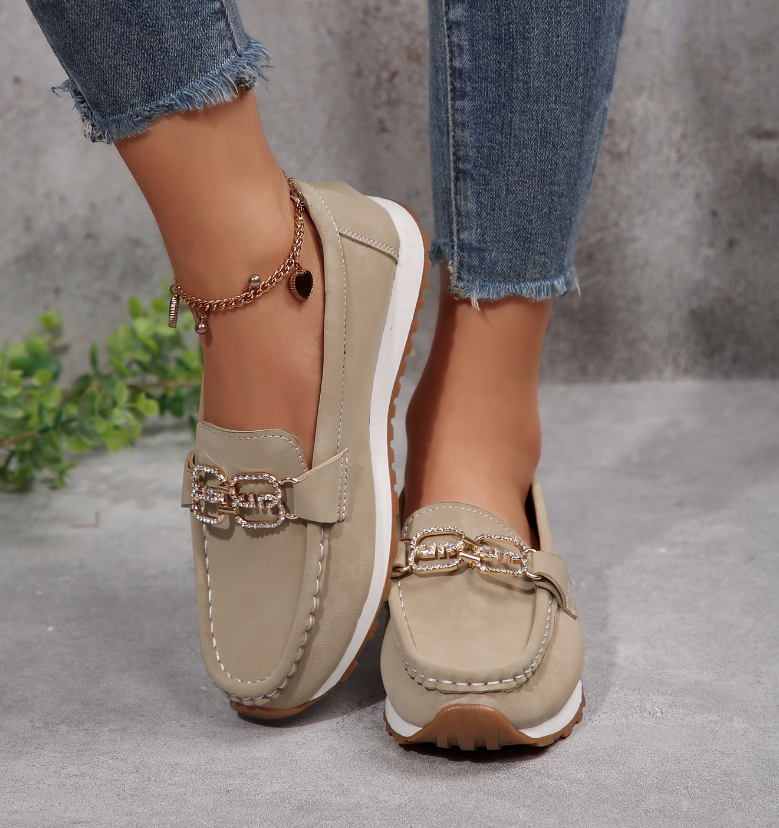Women's slip-on loafers with moccasin stitching and decorative buckle detail