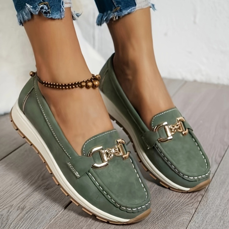 Women's green slip-on loafers with gold-tone buckle and white soles