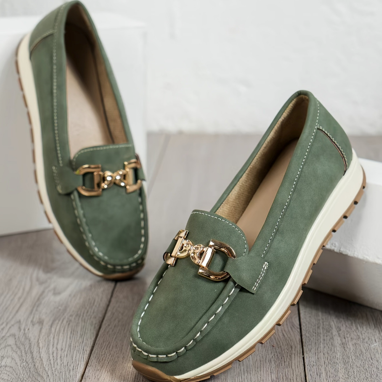 Women's green slip-on loafers with gold-tone buckle and white soles