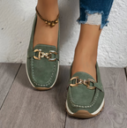 Women's green slip-on loafers with gold-tone buckle and white soles