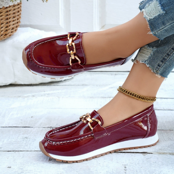 Women's burgundy glossy loafers with gold chain detail and flat textured soles