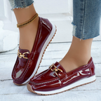 Women's burgundy glossy loafers with gold chain detail and flat textured soles