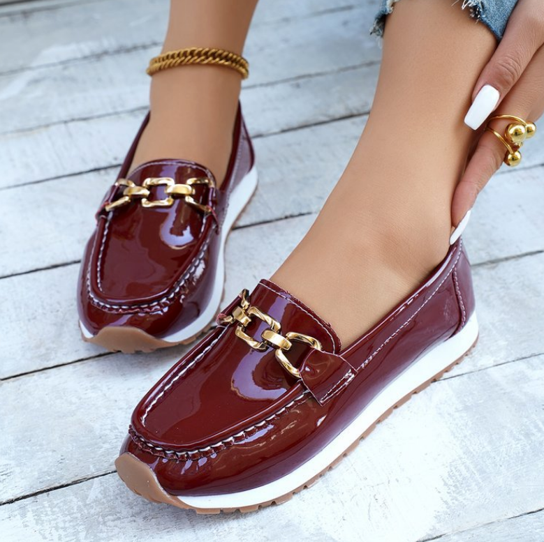 Women's burgundy glossy loafers with gold chain detail and flat textured soles