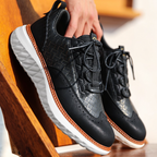 Hand-stitched sneakers with textured panels and ridged soles
