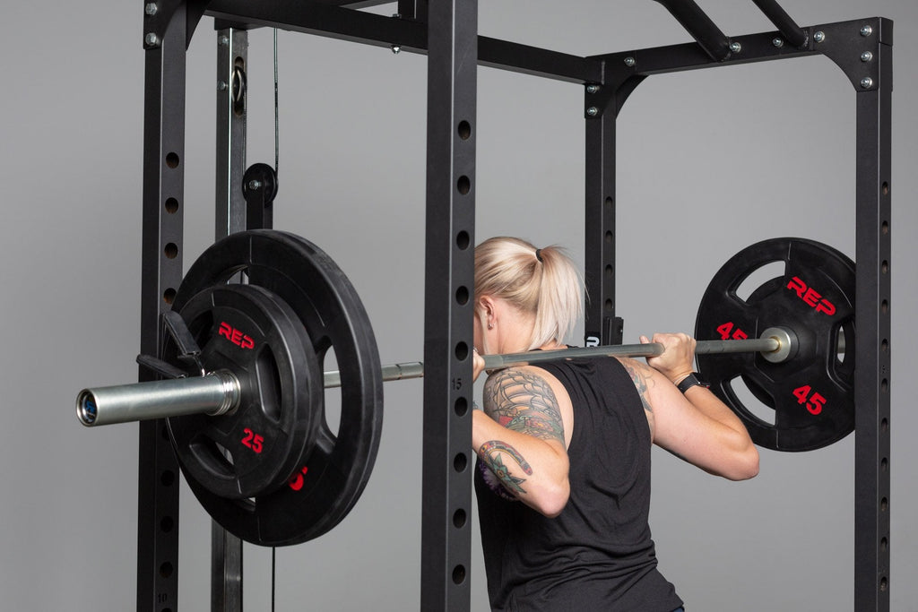 Black rubber coated Olympic weight plate marked 45 with three grip handles