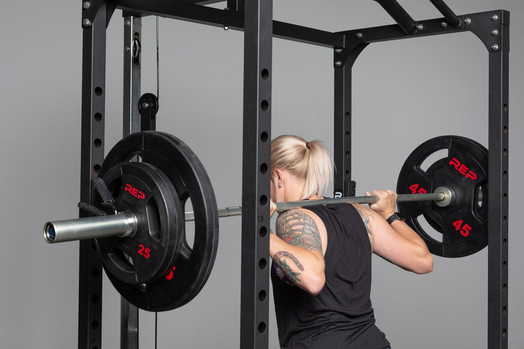 Black rubber coated Olympic weight plate marked 45 with three grip handles