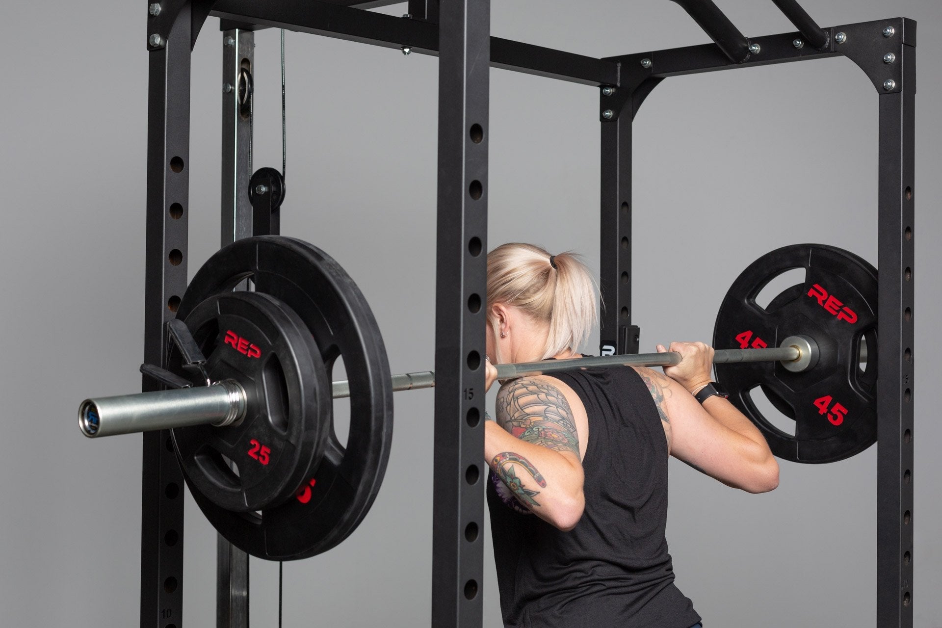 Black rubber coated Olympic weight plate marked 45 with three grip handles