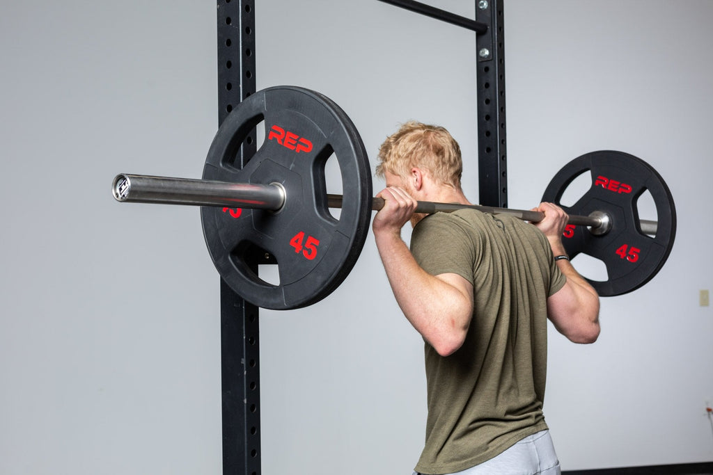 Black rubber coated Olympic weight plate marked 45 with three grip handles