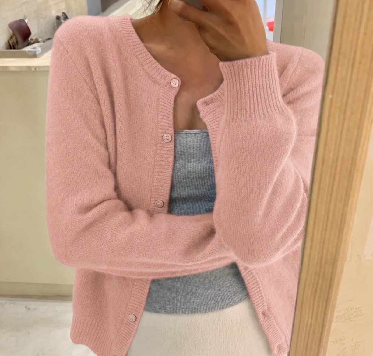 Women's waist-length knit cardigan with round neck and button front