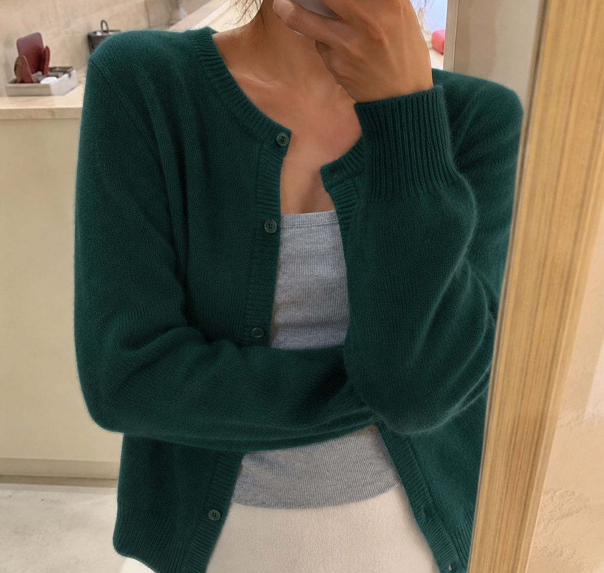 Women's waist-length knit cardigan with round neck and button front