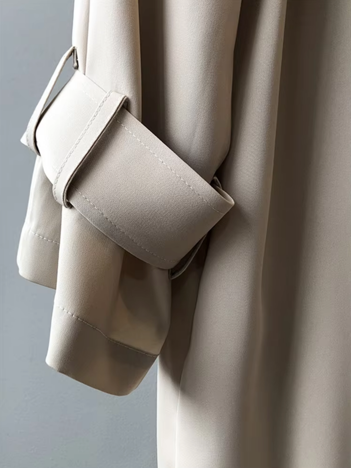 Women's long double breasted trench coat with lapel collar and cuff straps