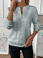 Women's textured cable knit sweater with round neckline and quarter-zip fastening