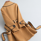 Women's long-sleeved belted trench coat with contrast piping and buttoned cuffs