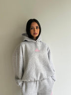 Women's light grey hoodie with pink chest logo and ribbed trims