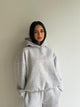 Women's light grey hoodie with pink chest logo and ribbed trims