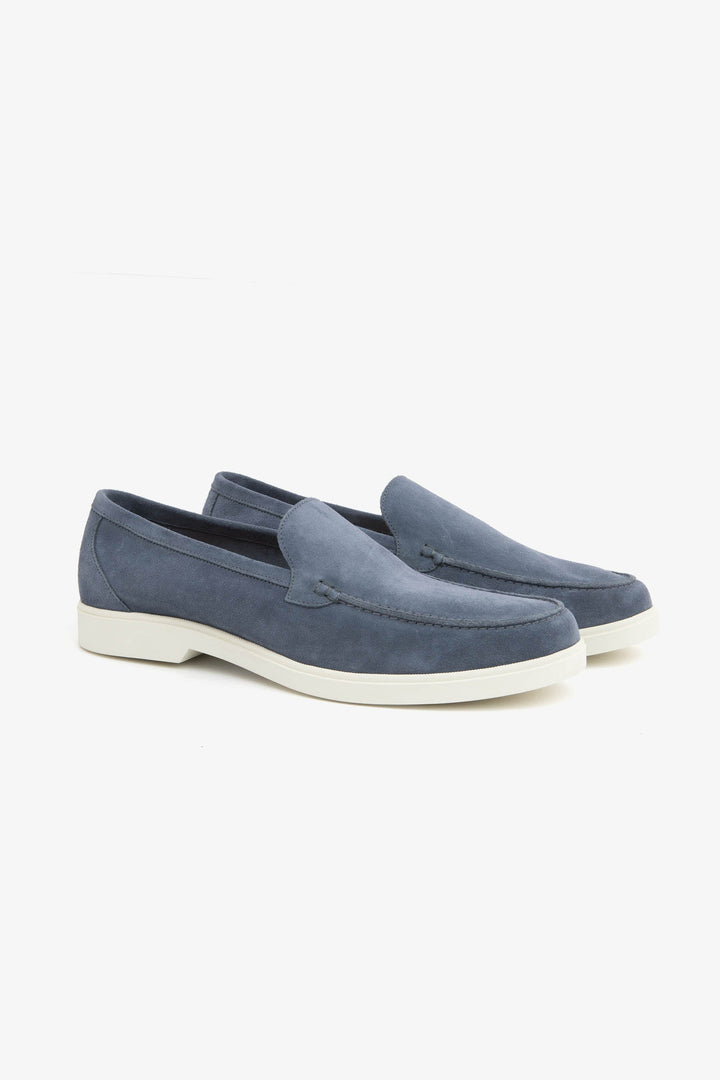 Blue men's slip-on loafers with moccasin stitching and cream flat soles