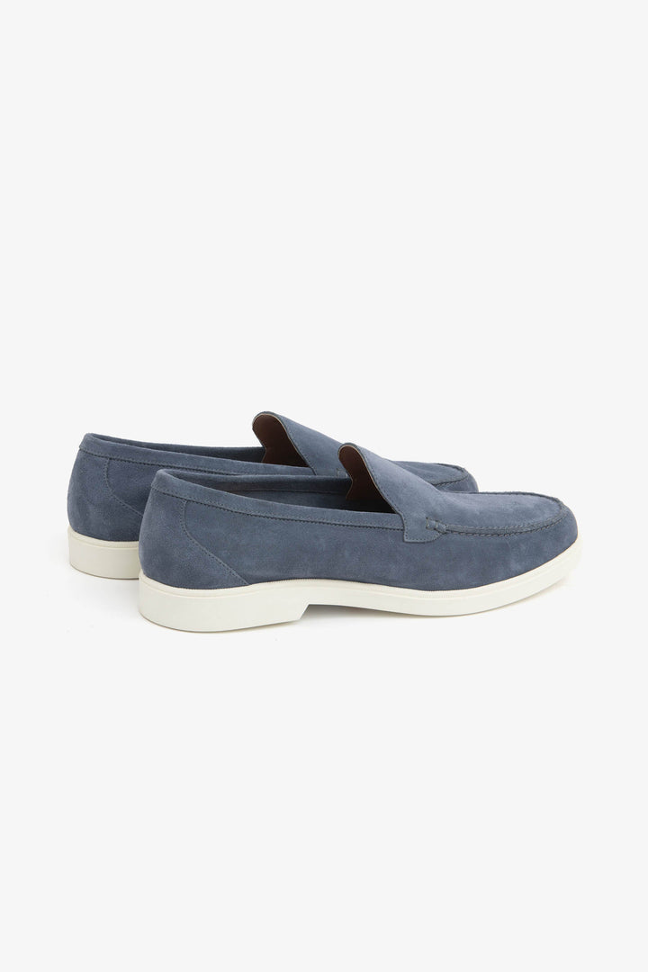 Blue men's slip-on loafers with moccasin stitching and cream flat soles