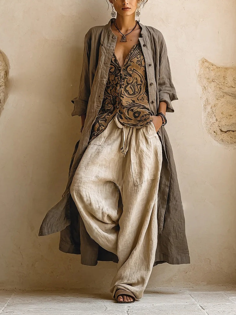 Woman wearing three-piece set with taupe button shirt, patterned scrollwork vest and cream wide-leg trousers