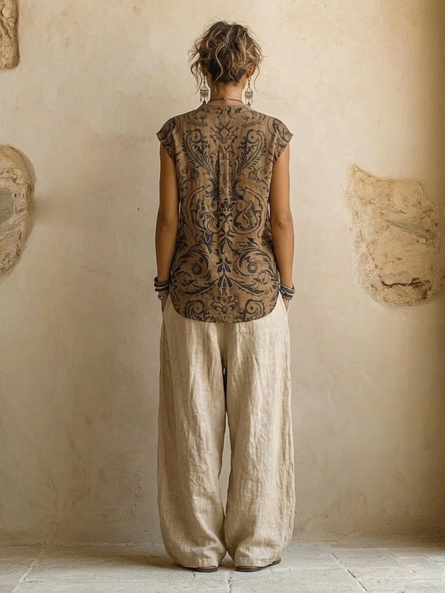 Woman wearing three-piece set with taupe button shirt, patterned scrollwork vest and cream wide-leg trousers