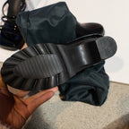 Black over-the-knee boots with block heels and lugged soles