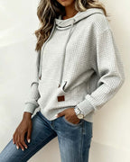 Women's grey waffle-textured hooded sweatshirt with drawstrings and front kangaroo pocket