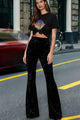 Woman wearing high-waisted wide-leg flared velour trousers