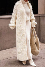 Women's longline chunky knit cardigan worn open over a high-neck jumper