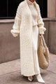 Women's longline chunky knit cardigan worn open over a high-neck jumper