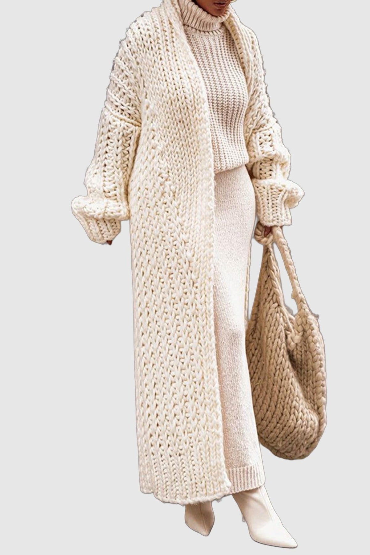 Women's longline chunky knit cardigan worn open over a high-neck jumper