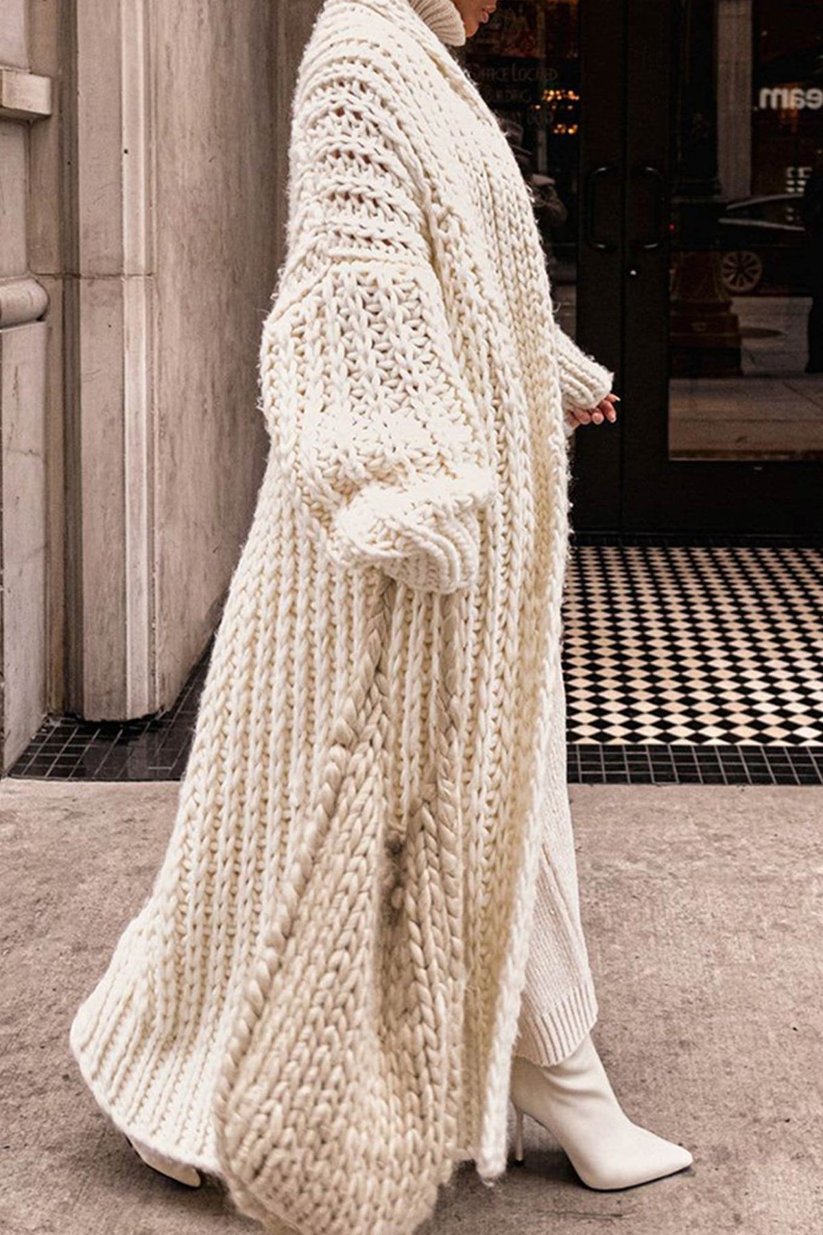 Women's longline chunky knit cardigan worn open over a high-neck jumper