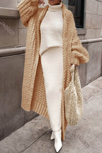 Women's longline chunky knit cardigan worn open over a high-neck jumper