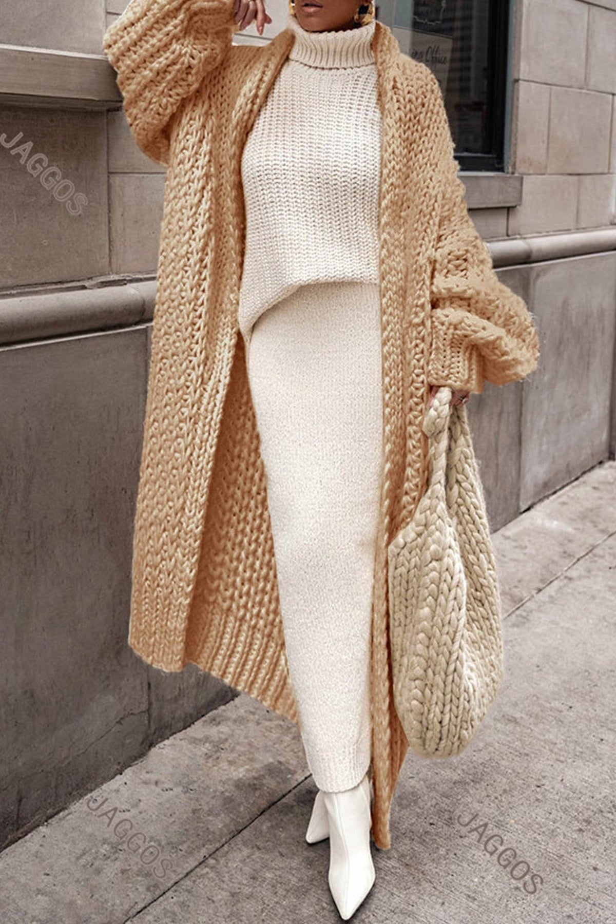 Women's longline chunky knit cardigan worn open over a high-neck jumper