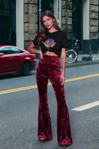 Woman wearing high-waisted wide-leg flared velour trousers