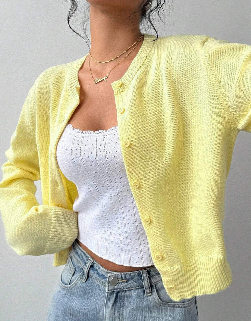 Women's cropped knitted cardigan with round neckline, long sleeves and front buttons