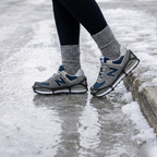 Black stretch ice cleats with traction chains fitted over boots