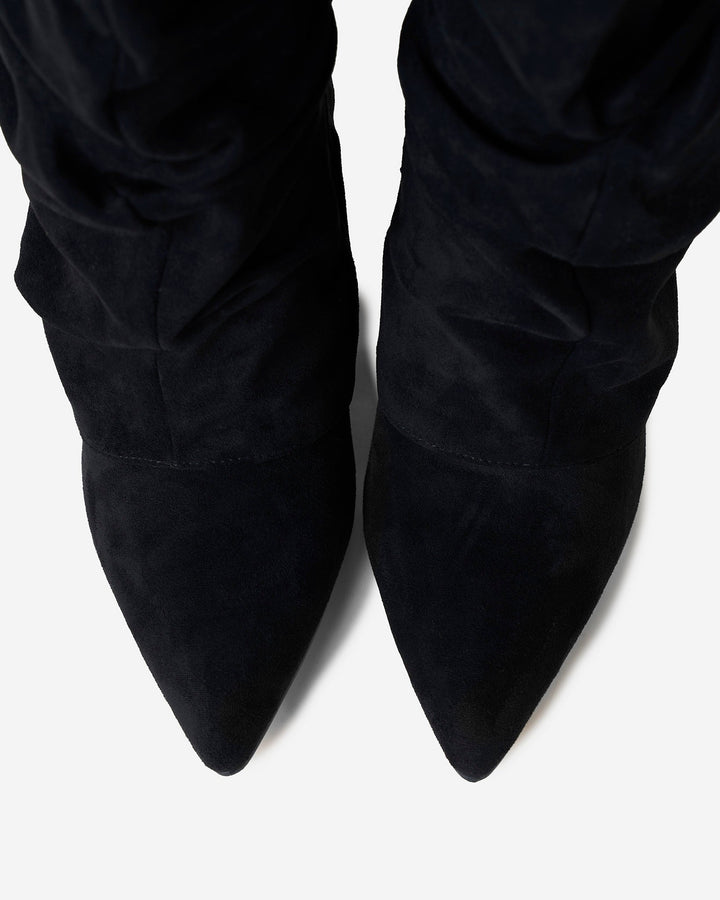 Women's black slouchy knee-high boots with pointed toes and buckled straps