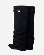 Women's black slouchy knee-high boots with pointed toes and buckled straps