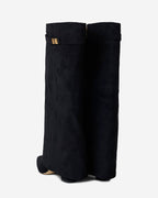 Black knee-high boots with pointed toes, buckle straps and low heels