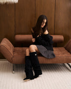 Women's black slouchy knee-high boots with pointed toes and buckled straps
