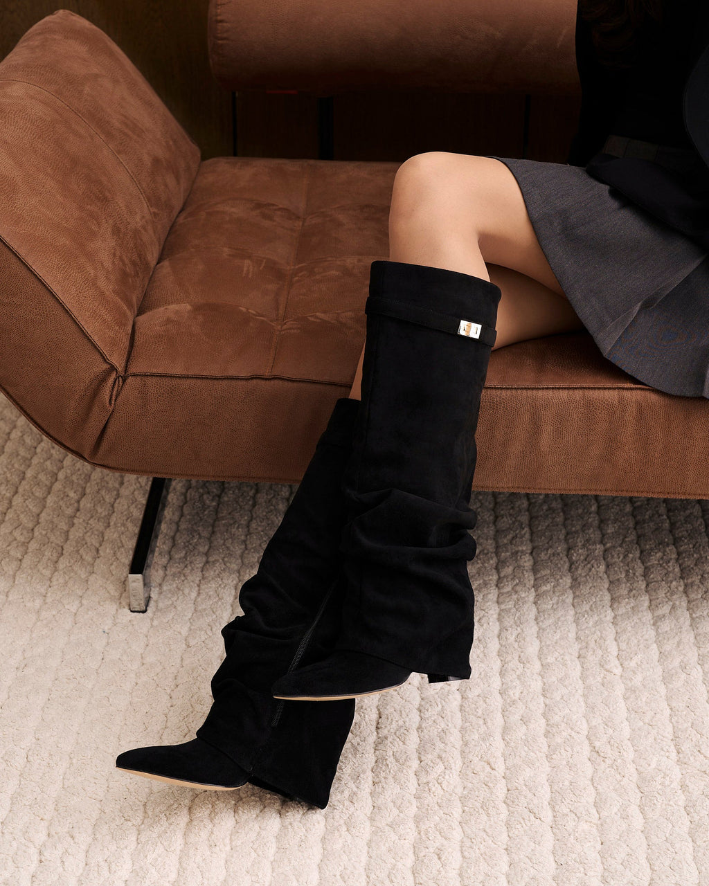 Women's black slouchy knee-high boots with pointed toes and buckled straps