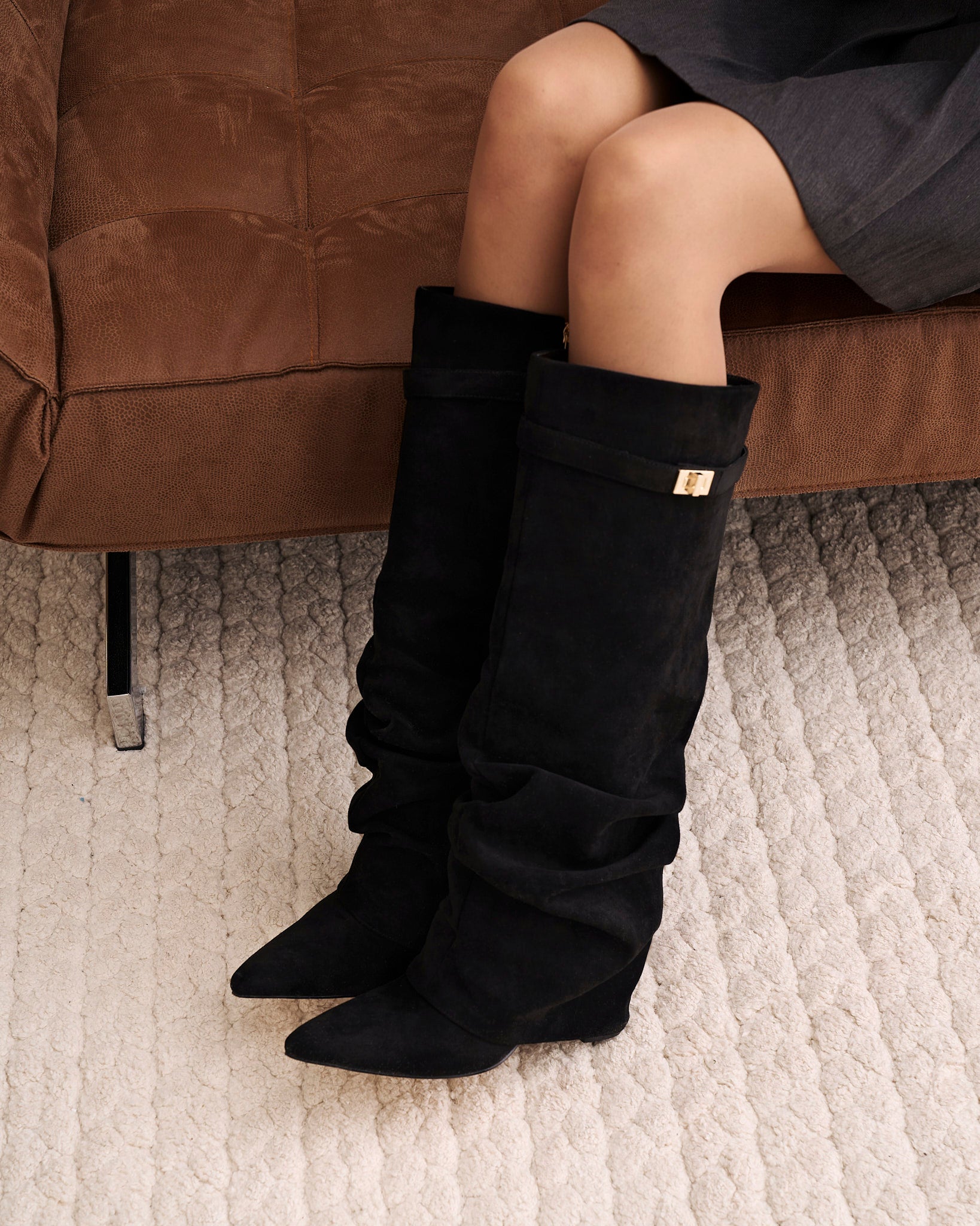Women's black slouchy knee-high boots with pointed toes and buckled straps