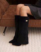 Black knee-high boots with pointed toes, buckle straps and low heels