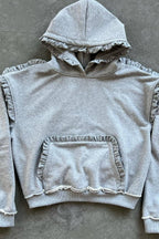 Women's grey pullover hoodie with ruffle trim around the hood and sleeves