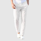 Men's beige relaxed-fit trousers with drawstring waist and flat front, full-length view.