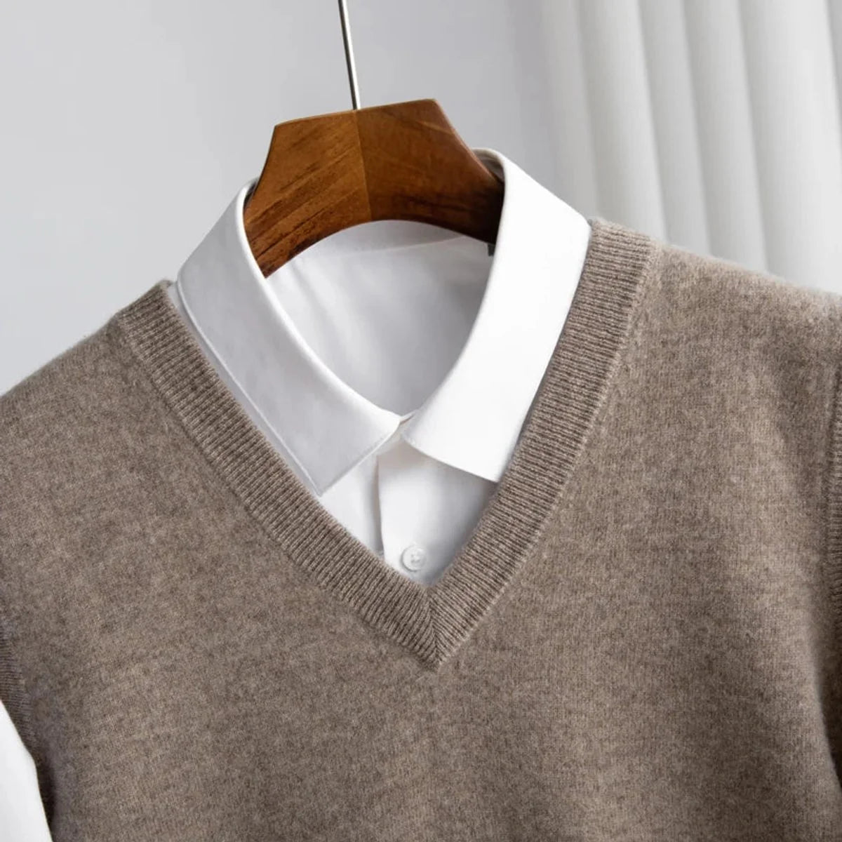 Men's V-neck knitted sweater vest layered over a white shirt