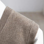 Men's V-neck knitted sweater vest layered over a white shirt