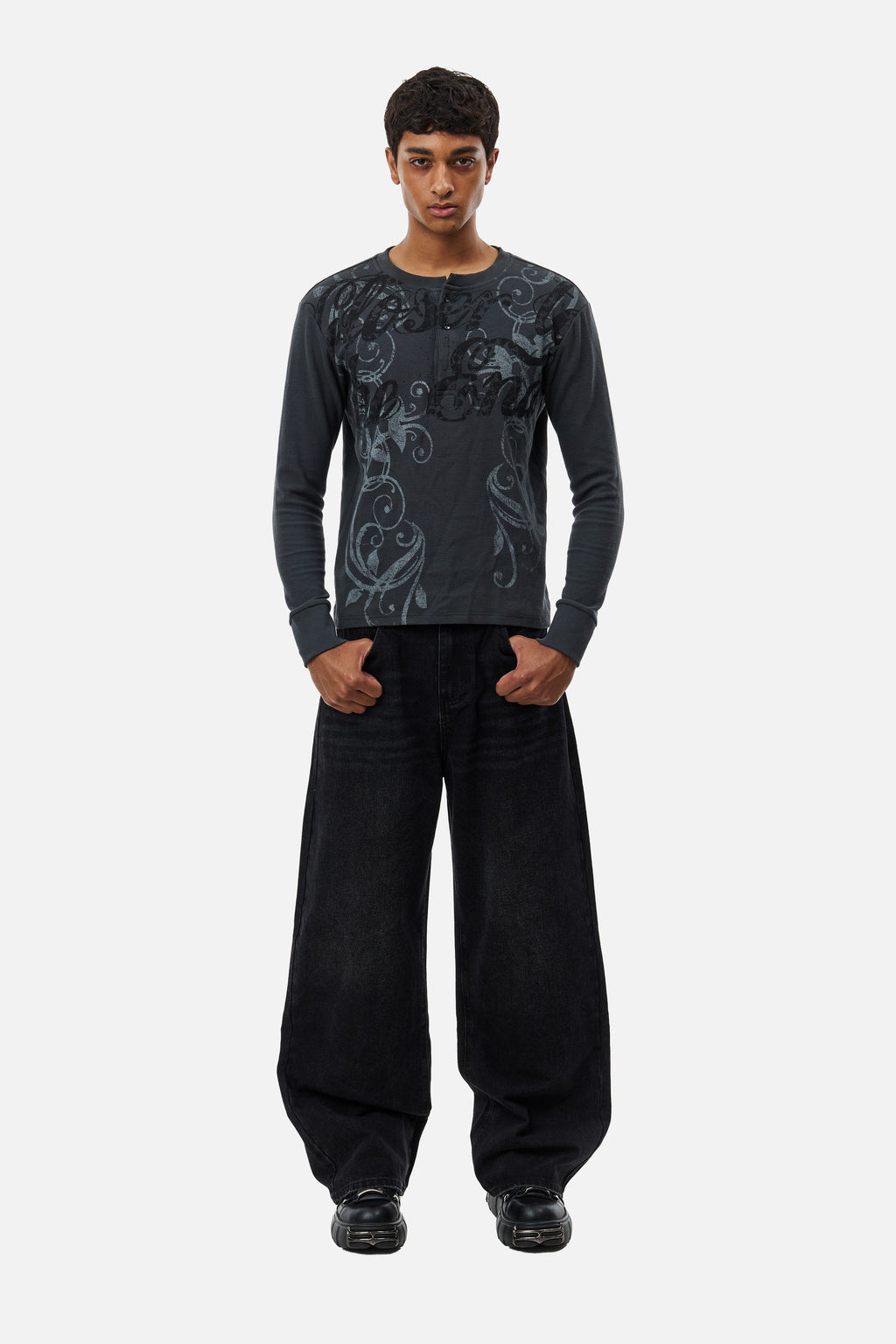 Men's black wide-leg jeans with graphic back pockets and gathered hems