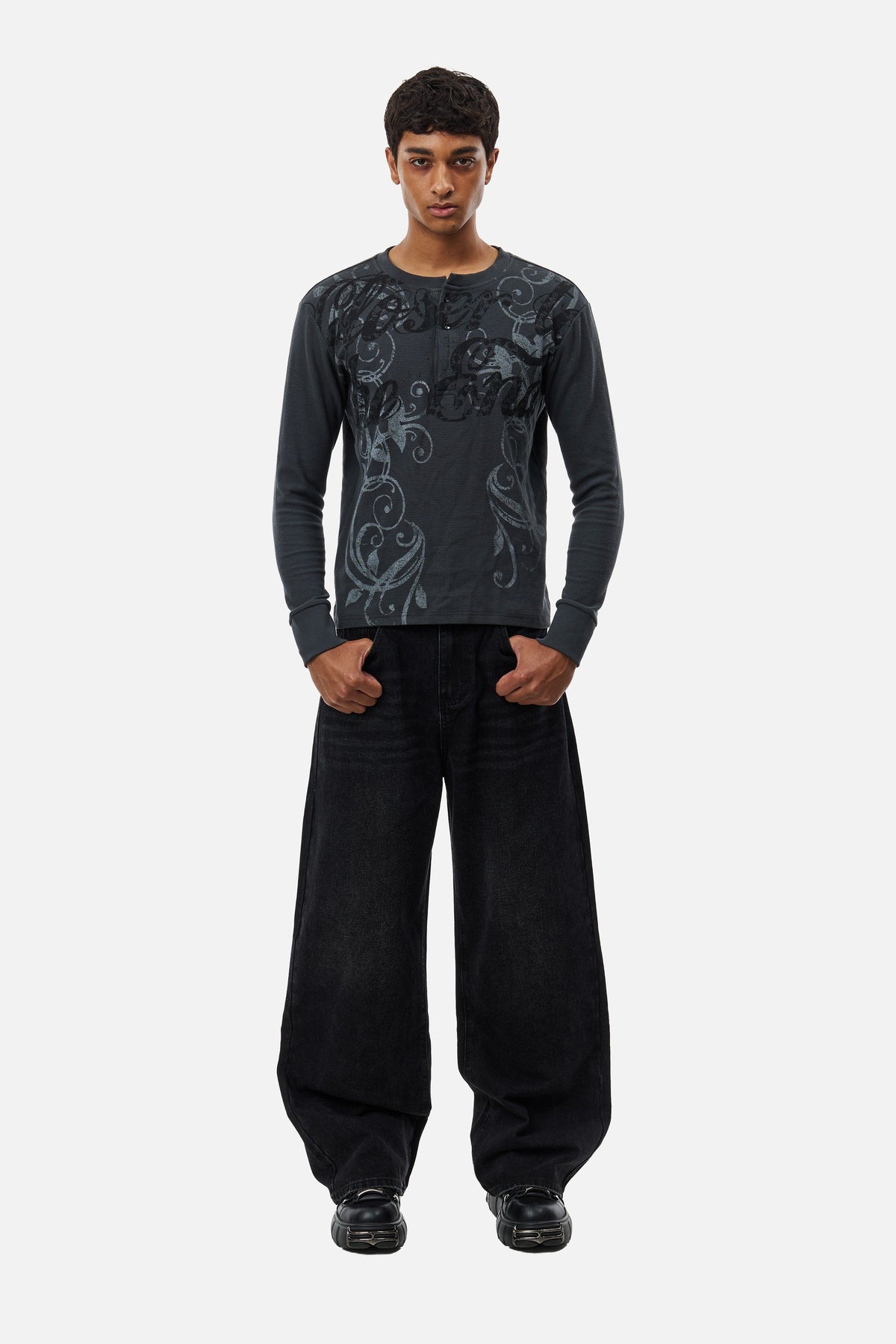 Men's black wide-leg jeans with graphic back pockets and gathered hems