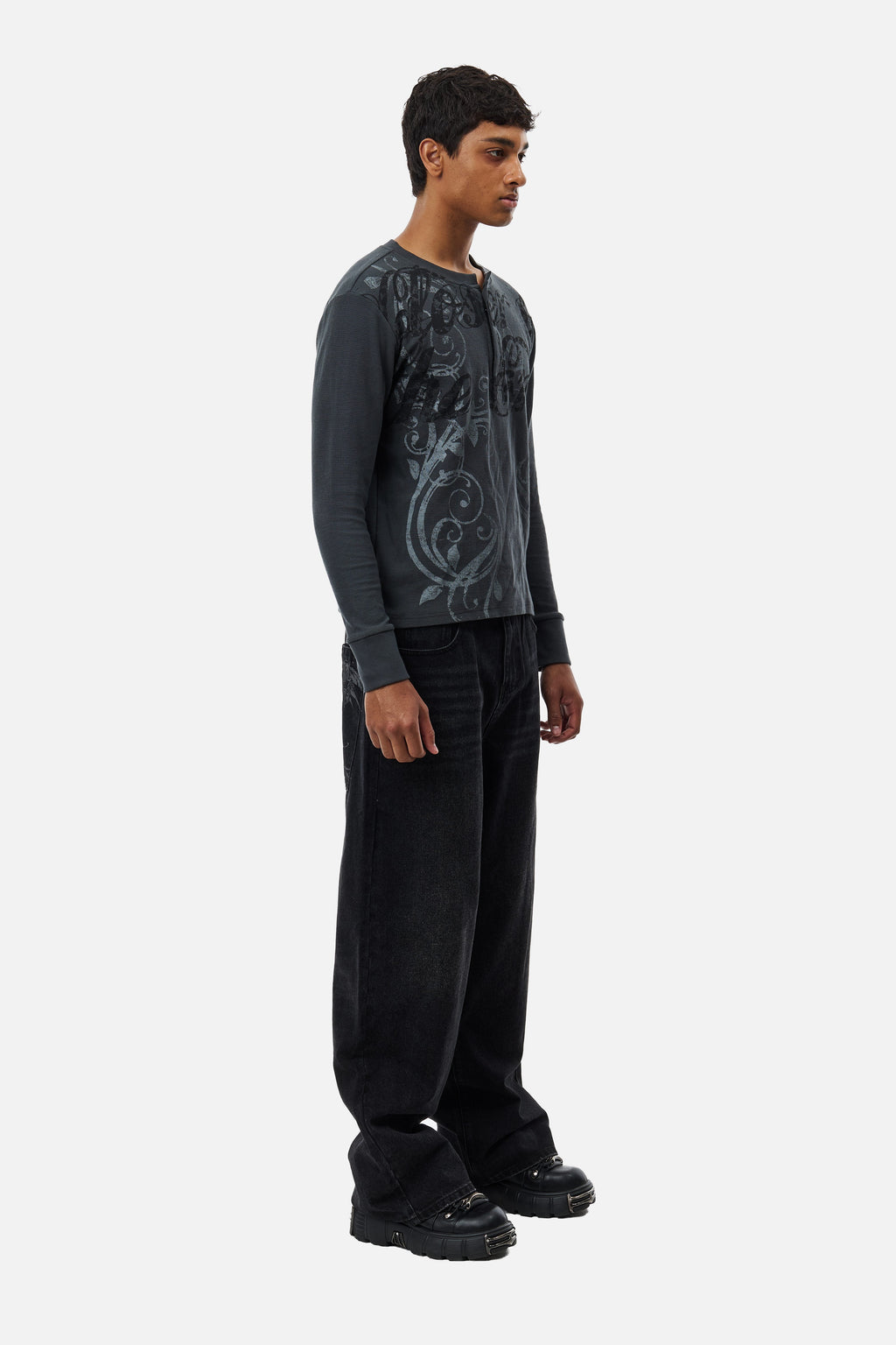 Men's black wide-leg jeans with graphic back pockets and gathered hems
