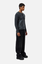 Men's black wide-leg jeans with graphic back pockets and gathered hems